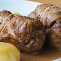 Dwie soczyste rolady śląskie w sosie własnym, podane z ziemniakami i kapustą. Pyszne danie obiadowe.