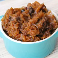 Pyszny bigos w turkusowej miseczce, gotowy do podania. Idealny przepis na polskie danie.