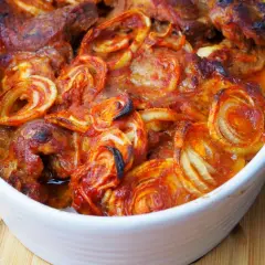 Karkówka pieczona w plastrach z cebulą i ketchupem, zapiekana w naczyniu.