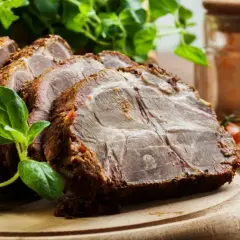 Rozpływająca się karkówka z piekarnika, soczysta i aromatyczna, podana z ziołami i pomidorkami.