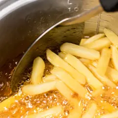 Frytki smażące się w głębokim oleju w garnku.