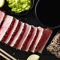 Pyszne tataki z tuńczyka w sezamie, podane z wasabi, sosem sojowym i limonką. Idealne danie dla miłośników ryb.