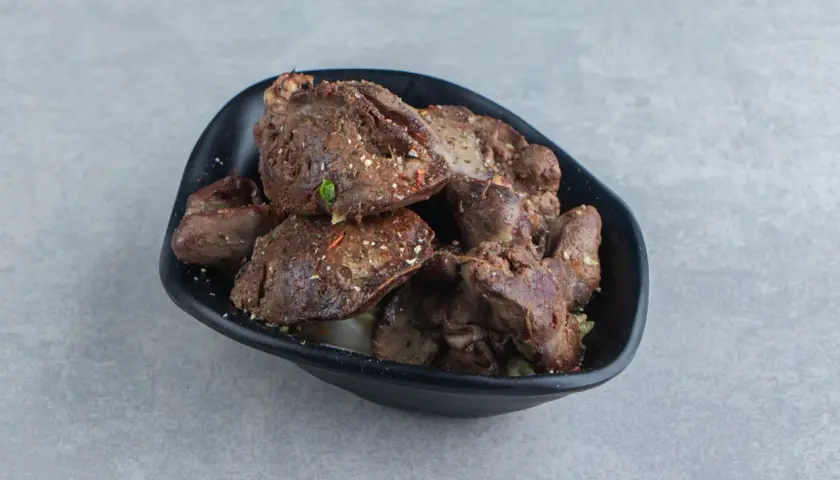 Aksamitna wątróbka z airfryer, doprawiona ziołami, podana w czarnej misce.