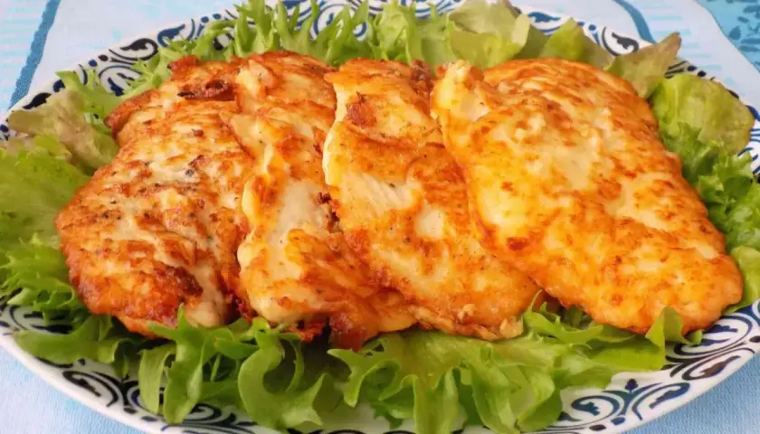 Złocisty kotlet drobiowy, idealnie usmażony, podany na chrupiącej sałacie. Pyszny obiad gotowy!