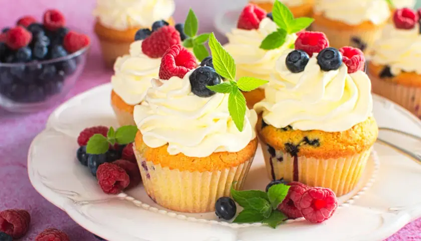 Pyszne babeczki z mascarpone, udekorowane malinami, borówkami i miętą. Idealne na deser!