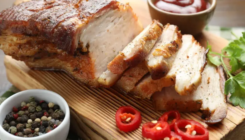 Soczysty boczek, idealny do pieczenia, pokrojony w plastry, z dodatkiem pieprzu, chili i ketchupu. Pyszny sposób, jak upiec boczek.