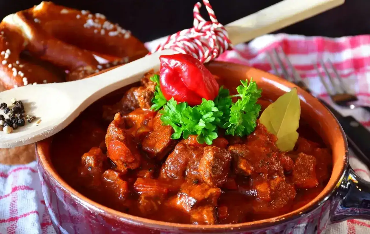 Gęsty, aromatyczny gulasz wołowy z papryczką chili i pietruszką. Idealny do podania z preclem. Dowiedz się, jak zagęścić gulasz, by był idealny!