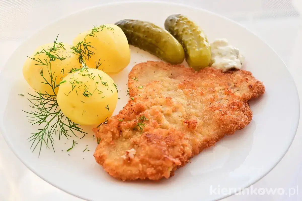 Pyszny kotlet schabowy Magdy Gessler, podany z ziemniaczkami, ogórkami kiszonymi i chrzanem.